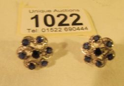 A pair of diamond and sapphire earrings.