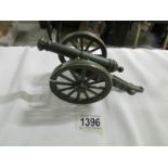 A brass model of a cannon painted green.