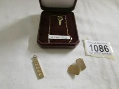 A 9ct gold '21' pendant, a gold ingot and a gold cuff link.