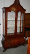 An inlaid display cabinet with drawer base.