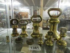 A set of brass bell weights and other brass weights.