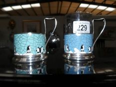 2 Russian enamel glass holders featuring penguin decoration.