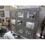 A silver coloured 9 drawer chest with mirrored top and mirrored drawer fronts.