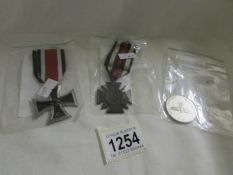 A 1914-18 German Hindenburg cross, an Iron cross and a 1939 Hitler commemorative coin.