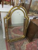 A gilt framed arched top mirror.