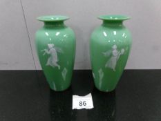 A pair of green Mary Gregory style vases.