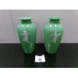 A pair of green Mary Gregory style vases.