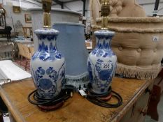 A pair of blue and white table lamps with shades.