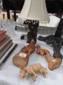 A carved wood table lamp, 2 carved figures and a carved cow.