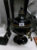 A large pottery tea urn with brass top.