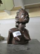 A wooden tribal bust of a woman.