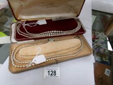 2 cased simulated pearl necklaces and 2 pairs of earrings,.