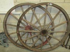 A large pair of old cart wheels.