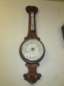 An Edwardian oak barometer with porcelain dial.