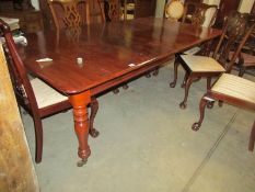 A mahogany extending dining table with 3 leaves.