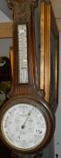 An Edwardian oak aneroid barometer with Admiral Fitzroy indications on porcelain dials.