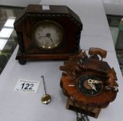 A small oak mantel clock and a miniature cuckoo clock.