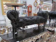 A black upholstered window stool.