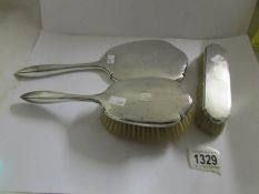 A silver backed mirror and brushes, hall marked Birmingham 1928/29, Walker and Hall.