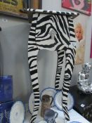 A modern stand with drawer painted in a zebra stripe.