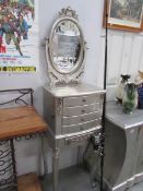 A silver coloured 3 drawer chest with mirror.