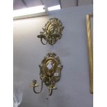 A pair of brass candle wall sconces.