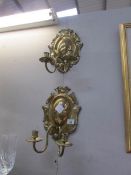 A pair of brass candle wall sconces.