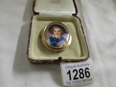 A German hand painted miniature portrait of a girl in gold mount.