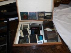 A pine box containing 20 assorted magic lantern slides and empty frames.