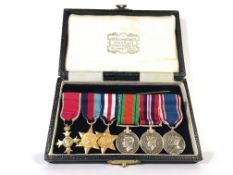 A cased set of 6 WW2 miniature medals, bar and ribbons including OBE.