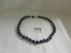 A blue stone necklace with clip and integrals in gold (possibly Lapis Lazuli).