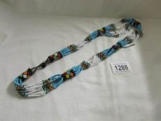 A bead necklace comprising white and turquoise coloured beads.