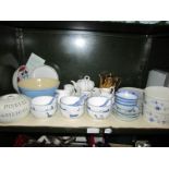 A shelf of miscellaneous including rice bowls and spoons