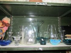 A shelf of assorted glass ware