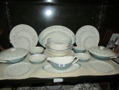 A shelf of Royal Doulton April Showers pattern dinner ware