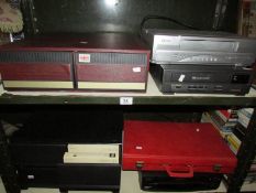 2 shelves of video cases with videos and 2 video recorders