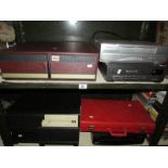 2 shelves of video cases with videos and 2 video recorders