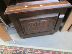 A 1930's oak coal box with carved panels