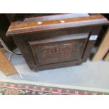 A 1930's oak coal box with carved panels