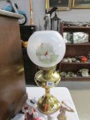 A brass oil lamp complete with chimney and shade with fox hunting transfer