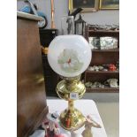 A brass oil lamp complete with chimney and shade with fox hunting transfer