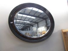 An oval framed mirror with bevel edge.