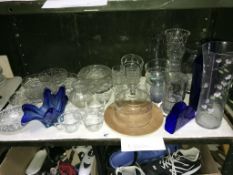 A shelf of glass ware including vases.