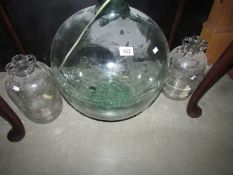 A large glass carboy and 2 wine making bottles.