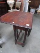 An oak gate leg table with pie crust edge.