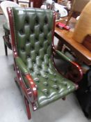 A mahogany and green leather rocking chair.