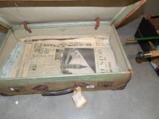 A vintage suitcase containing old newspapers.