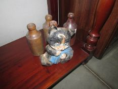 4 stoneware bottles and a cast iron cat door stop.
