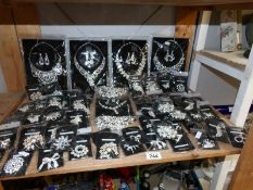 A shelf of bagged costume brooches and necklaces.