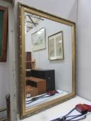 A large gilt framed bevel edged mirror,.